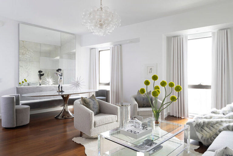 Four Seasons residence living and dining area with pale upholstered seating, a glass coffee table and a mirrored wall